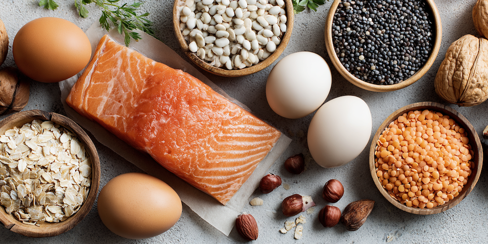 lebensmittel wie haferflocken, lachs, eier, linsen, nüsse